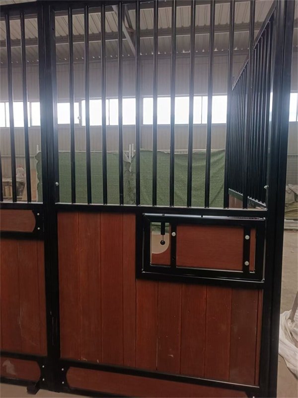 Workers constructing a custom horse stable with modular panels