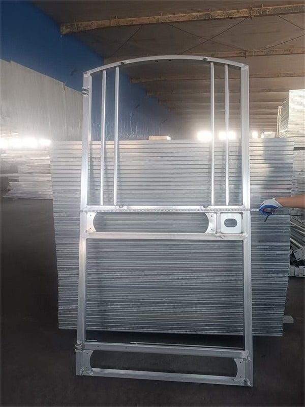 Workers assembling a durable horse stable in a factory setting