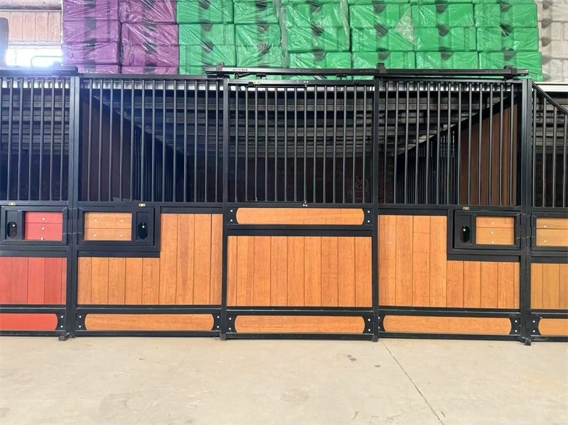 An interior view of a horse stable with multiple stalls, showcasing a combination of wood and metal materials, well-lit and organized.